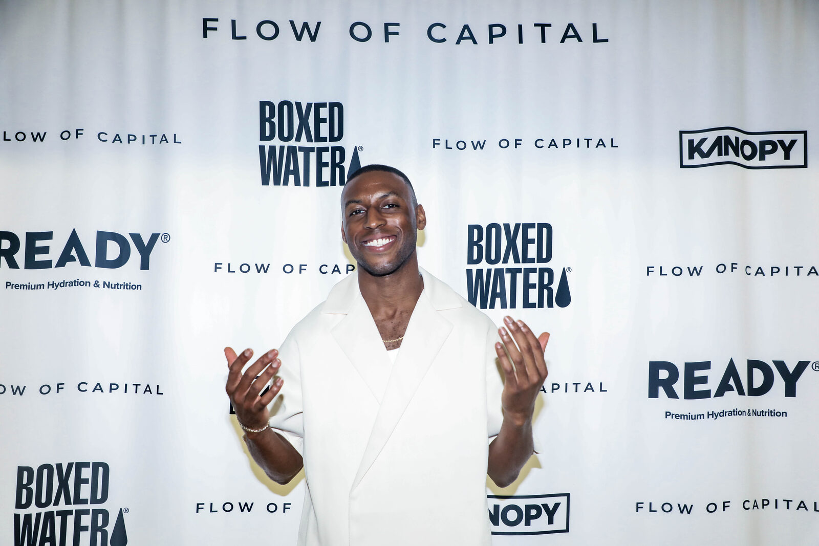 Dave at a Flow of Capital event in front of the partner step-and-repeat